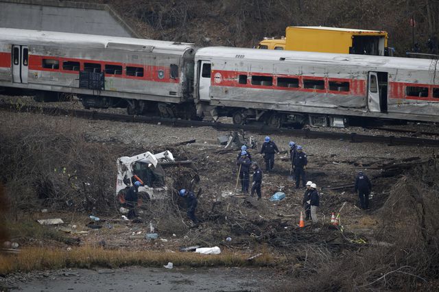 Emergency personnel search near the site of a train derailment in the Bronx section of New York in December 2013.